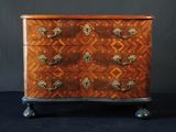 une commode ancienne avec un plateau en bois et des poignées en laiton