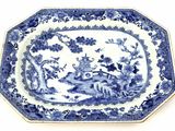 a blue and white plate with a landscape scene on it