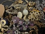 a pile of jewelry on a table with a black background
