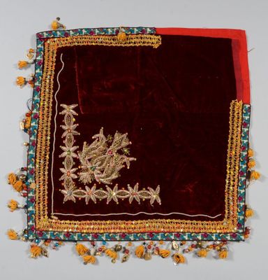 une image représentant un tissu brodé de rouge et d'or, orné de fleurs