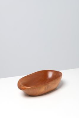 a wooden bowl sitting on top of a white table