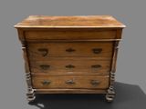 a small wooden chest of drawers on a gray surface