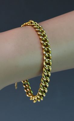 un gros plan sur le bras d'une personne portant un bracelet en or