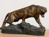 bronze statue of a lion on a rock on a table