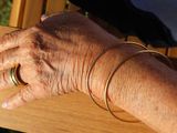 a close up of a person ' s hand on a wooden bench