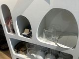 une étagère blanche sur laquelle sont posées des tasses et des verres
