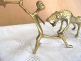a gold figurine of a man and a dog on a table