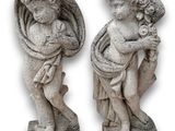 deux statues de chérubins tenant un bébé dans leurs bras