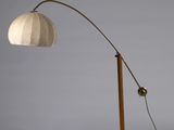un lampadaire en bois surmonté d'un abat-jour blanc