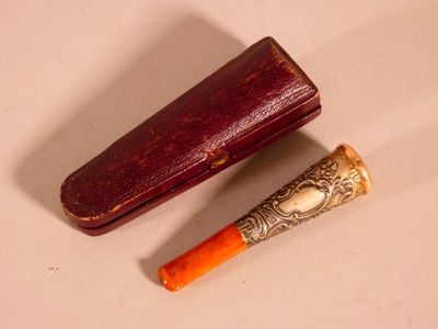 a wooden case with a metal handle next to a small orange tube