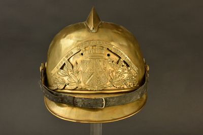 un casque doré orné d'une crête, posé sur un socle