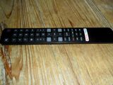 a remote control sitting on a wooden table next to a remote control