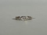 a close up of a diamond ring on a white surface
