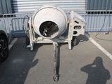 a cement mixer sitting in a parking lot next to a white car