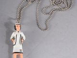 a necklace with a figurine of a woman holding a tennis racquet
