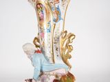 a figurine of a woman sitting on a vase