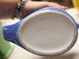 a person holding a blue and white cup in their hand