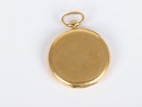 a close up of a gold plated pocket watch on a white surface