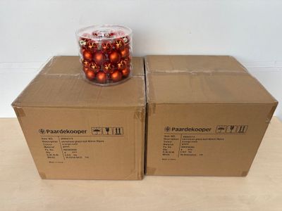 deux boîtes contenant des boules de Noël, posées sur une table