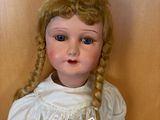 a doll that is sitting on the floor next to a wall