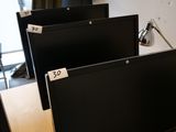 trois écrans d'ordinateur posés sur un bureau dans une pièce