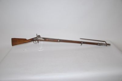 an old rifle with a wooden handle on a white surface