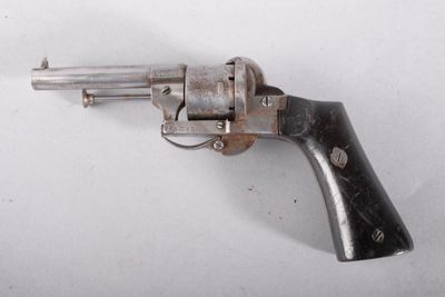 un revolver argenté posé sur une surface blanche, avec une crosse noire