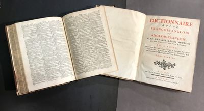 un livre ouvert posé sur une table à côté d'une table noire