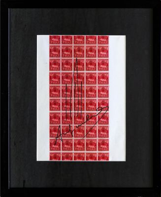une photo encadrée, de couleur rouge et blanche, sur laquelle figure une signature