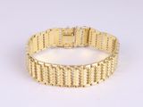 a close up of a gold bracelet on a white surface
