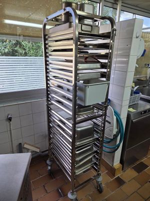 une étagère métallique avec des plateaux posés dessus, dans une cuisine