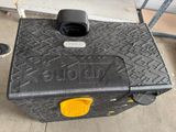 une valise noire avec une poignée jaune posée par terre