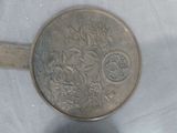 a silver plate with a design of flowers and birds on it