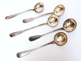 six silver spoons are lined up in a row on a white surface