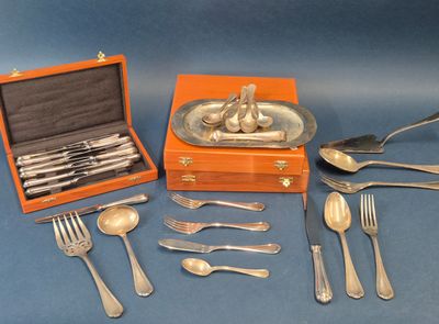 des couverts en argent présentés dans un coffret posé sur un fond bleu