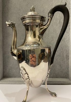 a silver tea pot sitting on a white table