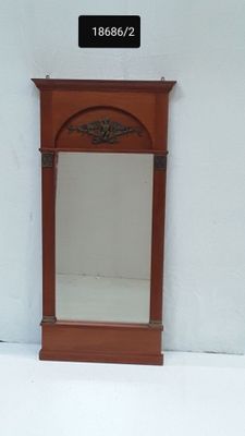 un petit miroir accroché au mur, à côté d'un mur blanc