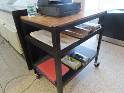 a printer sitting on top of a cart in a kitchen