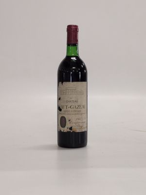 a bottle of red wine sitting on top of a white table