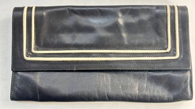 porte-monnaie en cuir noir avec des finitions dorées sur fond blanc