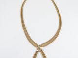 a gold chain necklace with a bow pendant