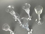 four wine glasses sitting on a table next to each other