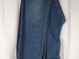 denim pants hanging on a clothes rack on a white sheet