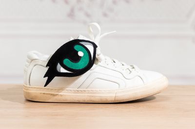 un gros plan sur une paire de chaussures ornées d'yeux verts