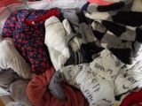 a pile of clothes sitting on top of a bed