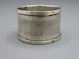un porte-serviettes ancien en métal argenté posé sur un support gris