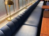 a row of blue couches in a room with a window