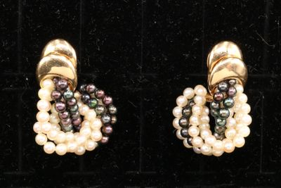 two pairs of pearl and gold earrings on display in a display case