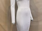 the dress is white and has long sleeves and a frillying hem