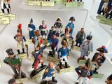 a lot of figurines that are on display in a glass case